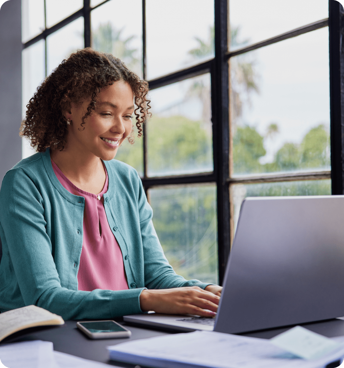 Smiling woman working on a laptop.