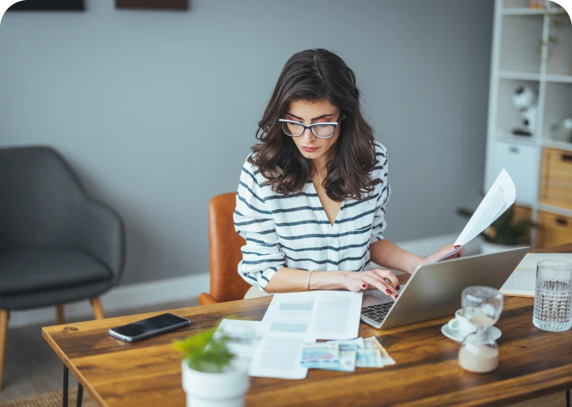 Woman working at desk with laptop.
