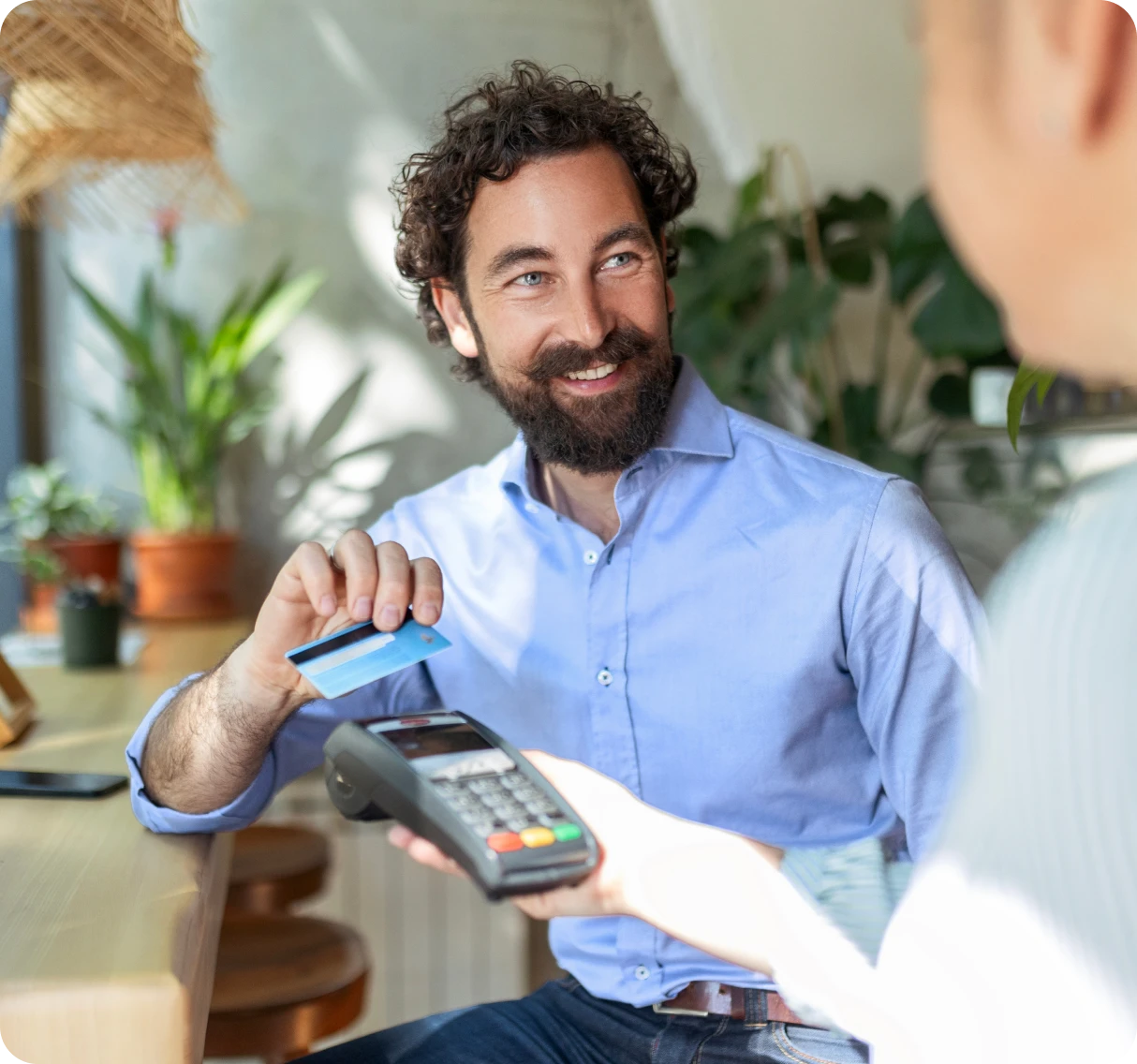 Man paying with card at cafe counter.